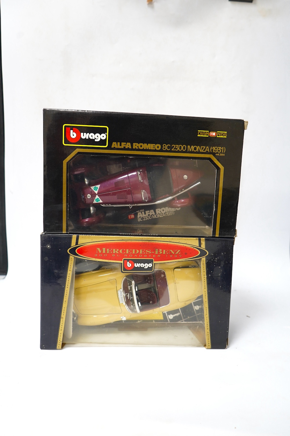 Eight boxed 1:18 scale diecast cars by Bburago, Maisto, etc. including; a Mercedes-Benz 300 SL, an Alpha Romeo 8C 2300 Monza, a Porsche 356B, a Triumph TR3A, etc. Condition - good.